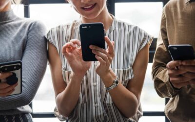 Three people scrolling through their phones.