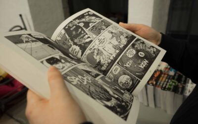 Man holding a black and white comic book