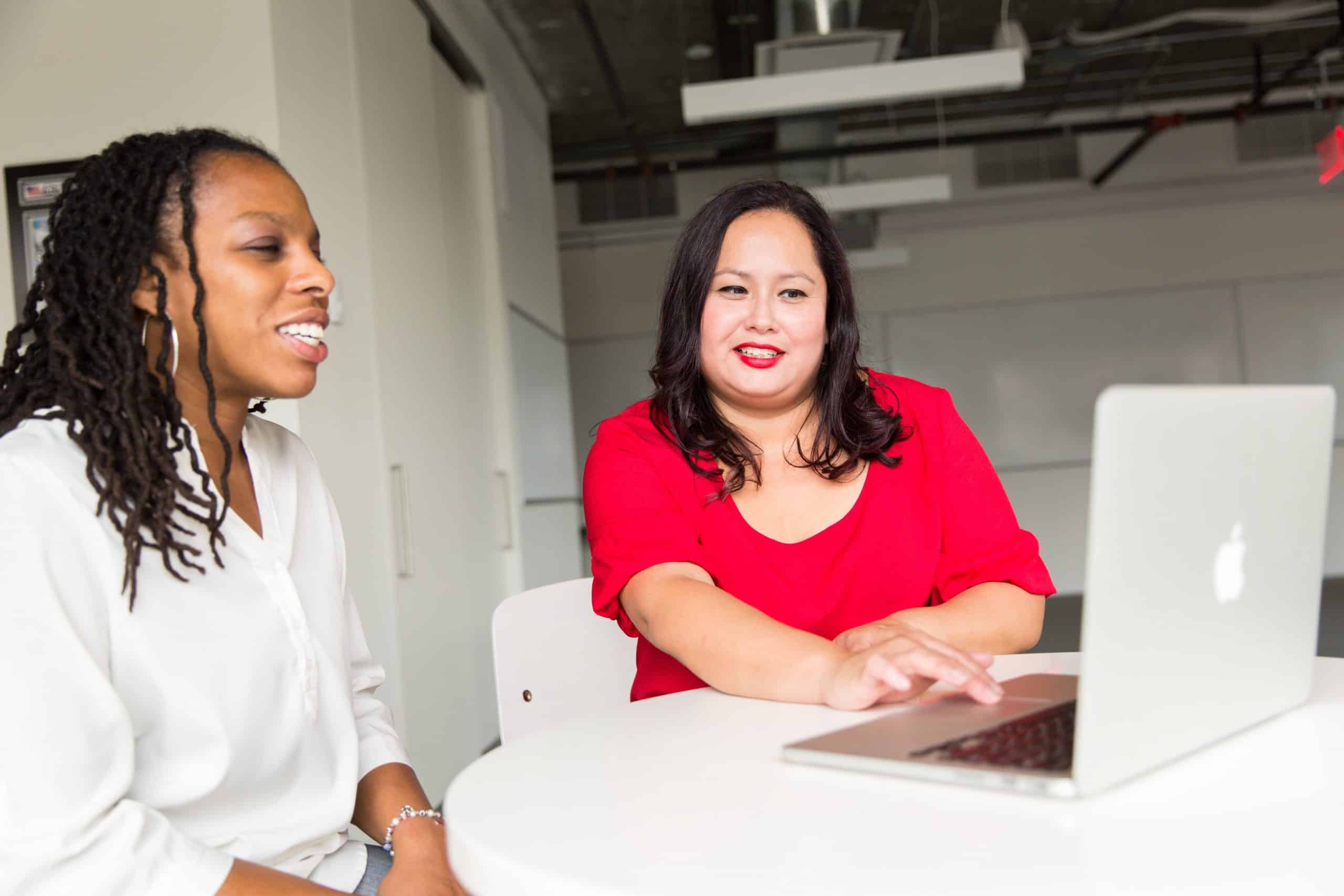 2 women. Employee helping a customer on a laptop