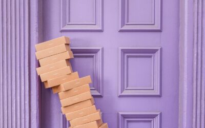 stack of shipping boxes leaning on a purple doorway