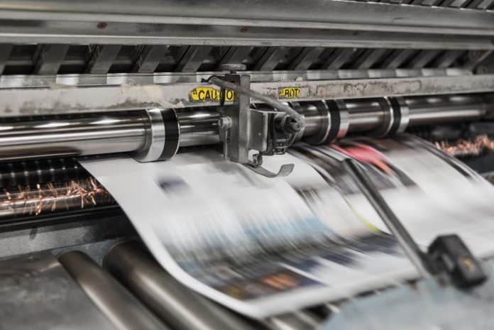 paper coming out of a printing press