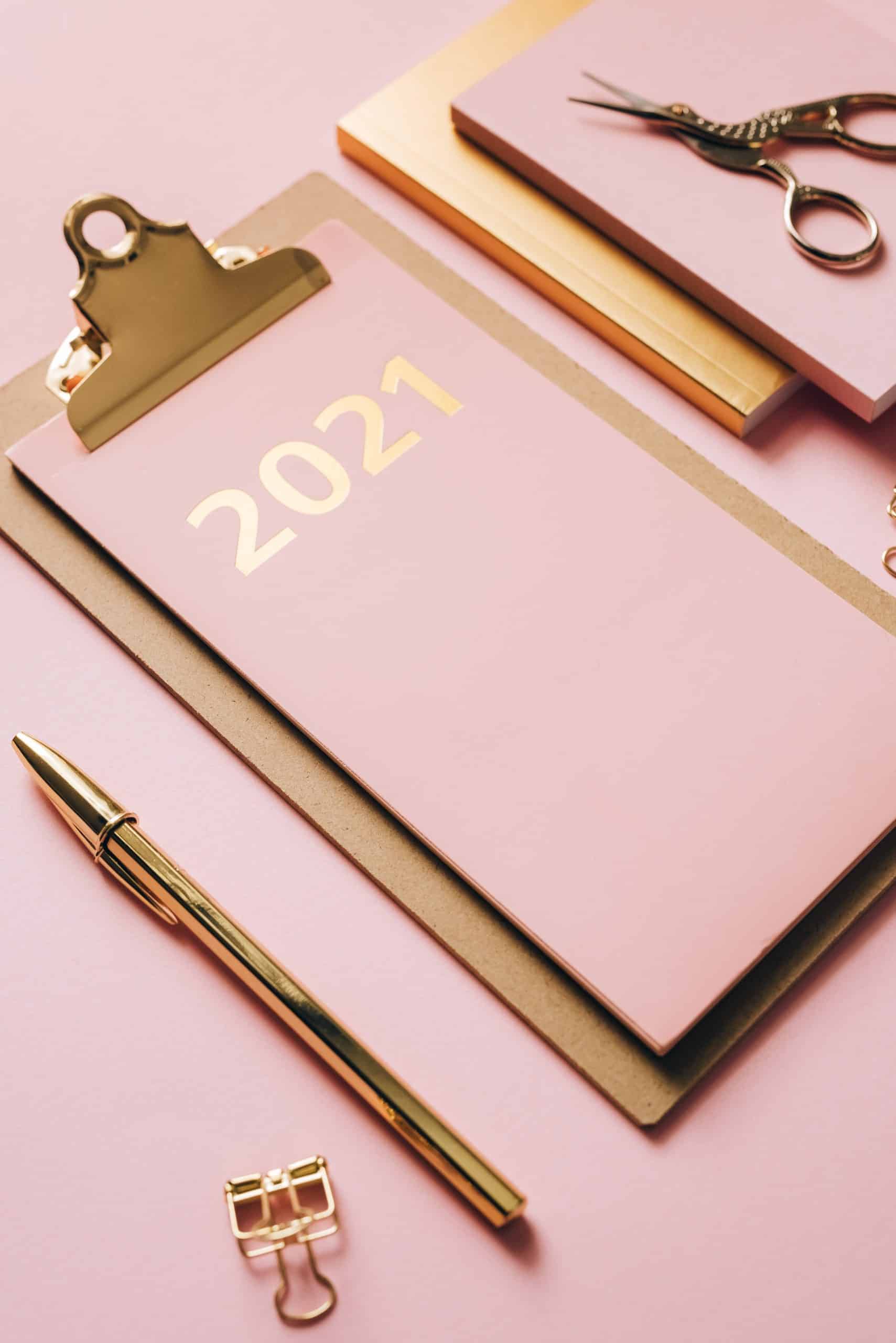 Pink paper with gold foil embossing on a clip board