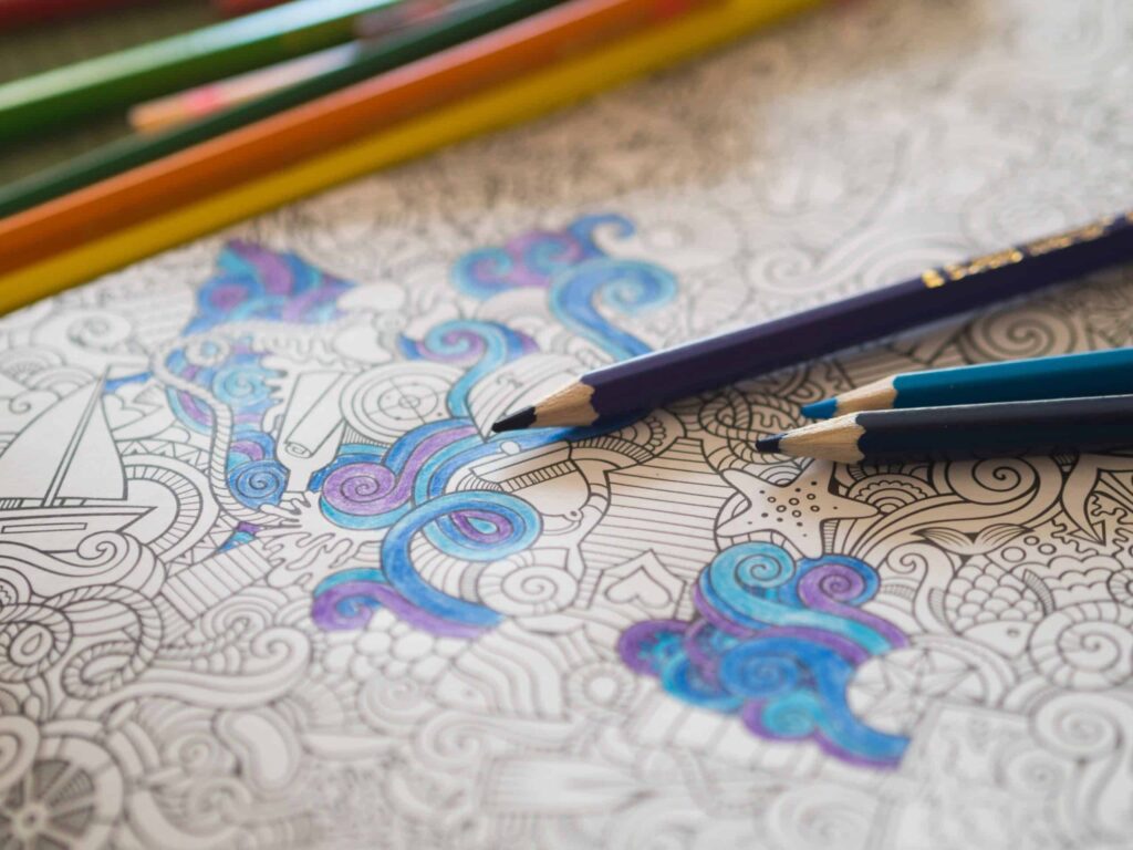 Adult coloring book outline with some sections filled in with colored pencils