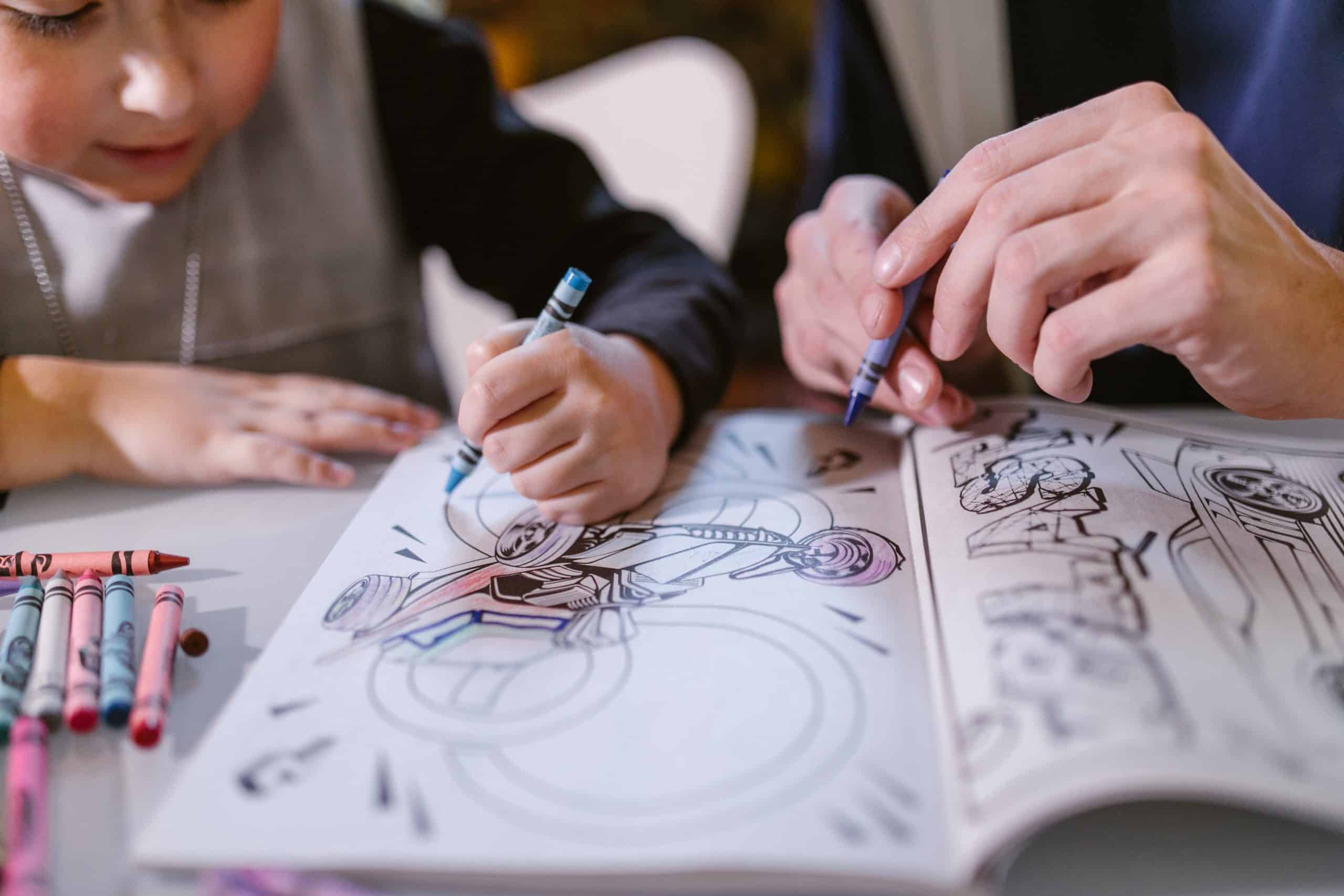 A child and adult coloring in a book together