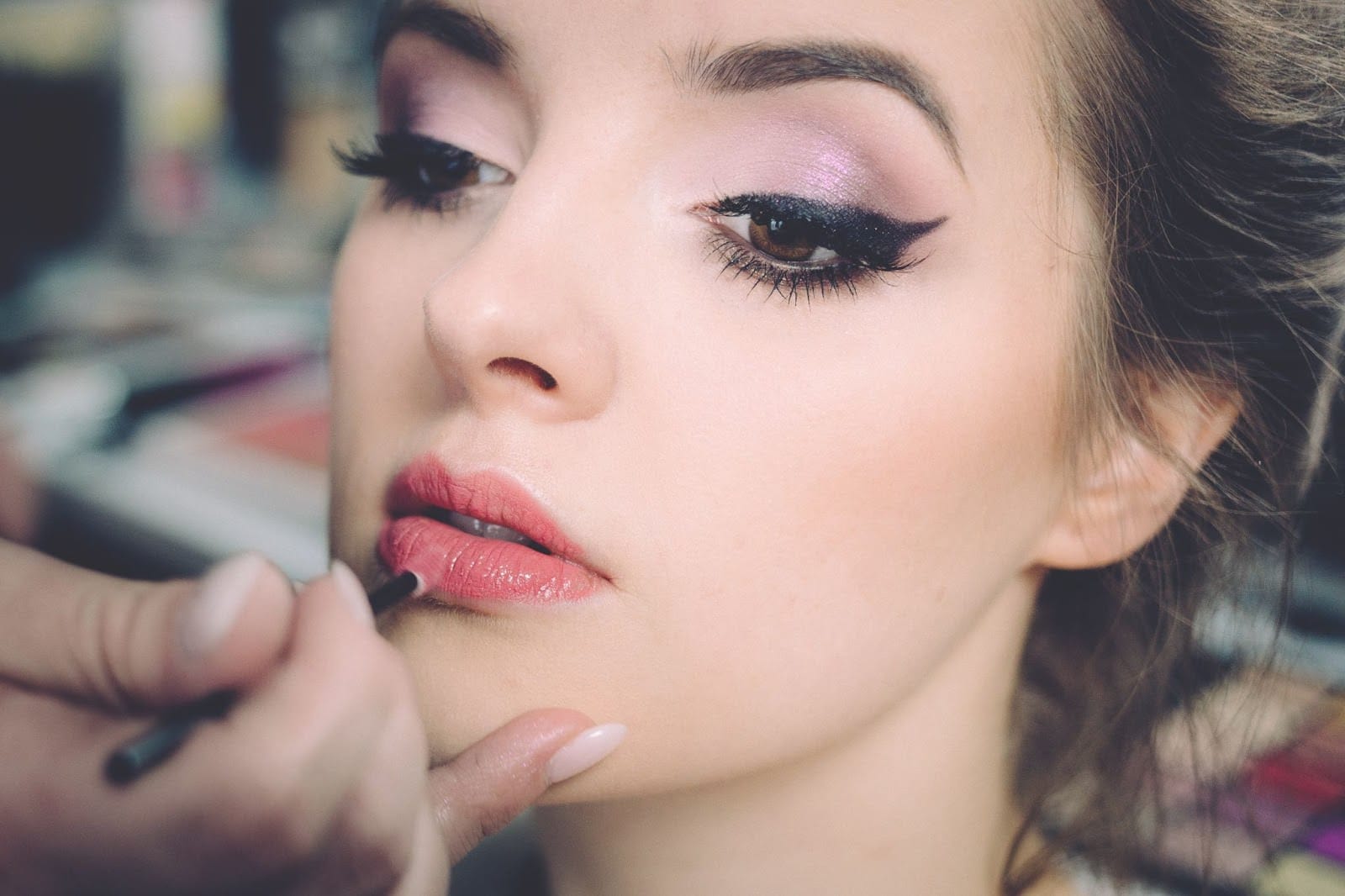 Women getting makeup applied on her face